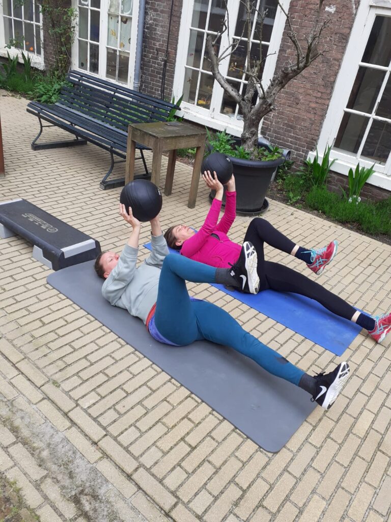 Twee dames in sportkleding trainen in de achtertuin