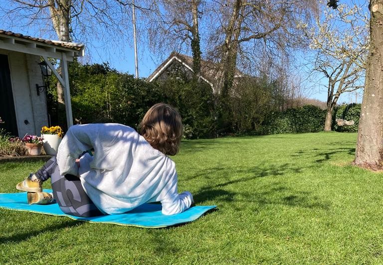 Vrouw in sportkleding traint buiten in het gras