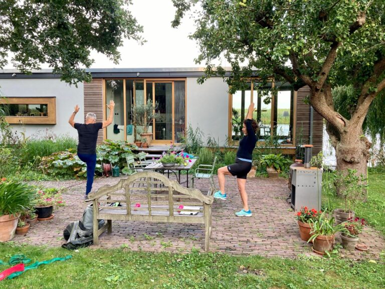 Man en vrouw in sportkleding trainen buiten bij hun huis