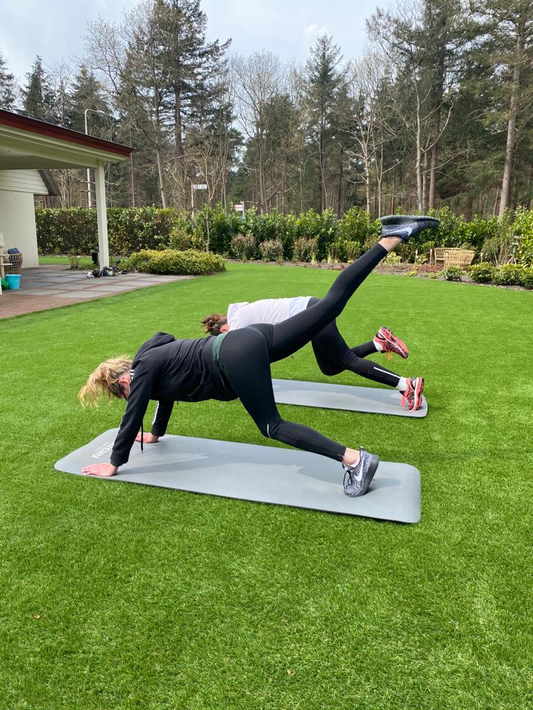 Twee dames in sportkleding trainen in de achtertuin