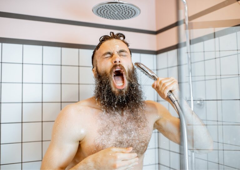 Man staat onder de koude douche en schrikt van het koude water!