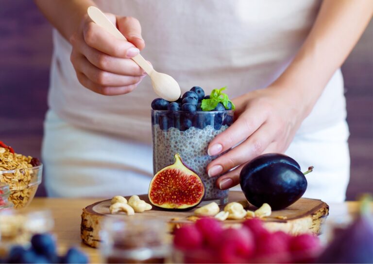 Vrouw wil een hapje nemen uit een potje yoghurt met fruit.