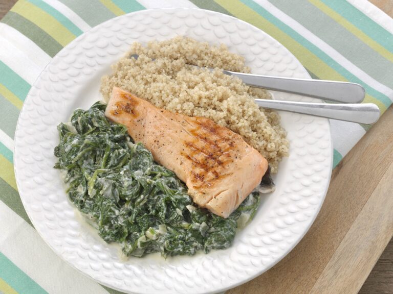 Bord met gegrilde zalm met spinazie en quinoa